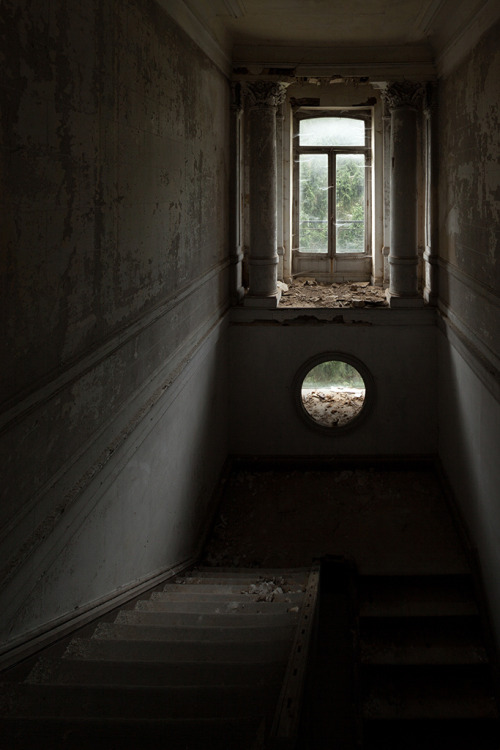 abandonedography: Strange round window in the staircase of an abandoned castle, France, Noir de