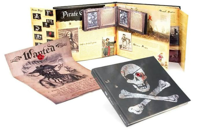The book "Pirates", a black book with a skull and crossbones on it, one eye of the skull covered with an eye patch, the other filled with a red plastic gem. The book is open and showing open flaps, and a wanted poster of blackbeard that's been presumably pulled from one of them