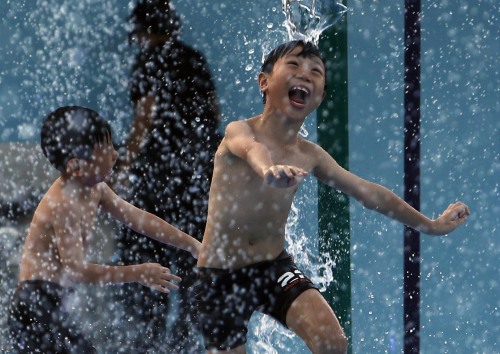 yahoonewsphotos:  Photos of the day - February 27, 2014 Children cool off in Singapore, a protester, with her mouth taped, takes part in a protest against the detainment of Al Jazeera journalists in Egypt, Asiatic lion Shiva, the mother of three cubs,