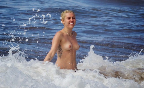 prettylittlerulebreaker:  thenudecity:  Here is Miley Cyrus topless wearing only her bikini bottoms and enjoying the surf at the beach in Hawaii. Cyrus  seems to be going out of her way to show us her naked body in 2015. And  this time around her boobs