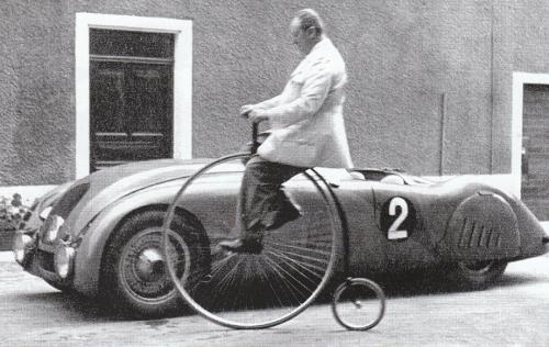 gibier3000:  Ettore Bugatti rides a penny farthing, with the winning Bugatti type 57G “Tank&rd