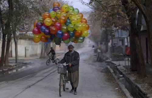 fotojournalismus:An Afghan balloon vendor looks for customers in Kabul on November 7, 2011. (Muham