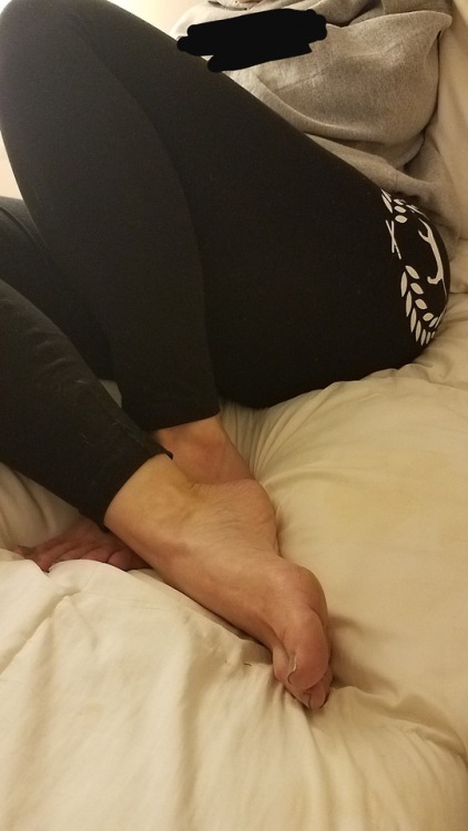 My pretty wife looking very cute just relaxing in bed barefoot in her yoga pants.please comment