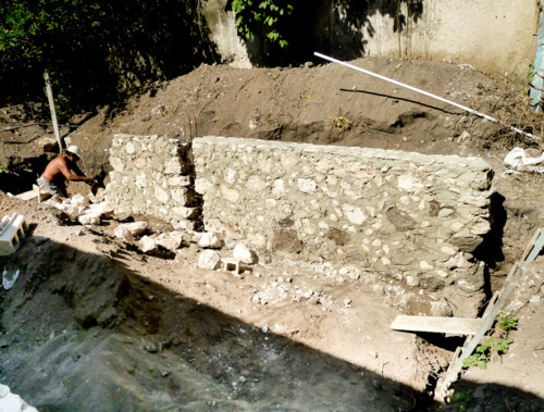 Using mamposteria stacked stone to build the perimeter and footing for the swimming pool