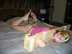 putmeinherplace:  A quite unusual bed bondage. These home made stocks are a fine piece of kinky gear. The ropes pulling the ankles in a hogtie like manner are a nice touch. 