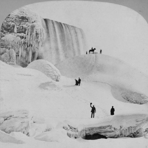vintageeveryday:

People used to walk to Canada across frozen-over Niagara Falls.As temperatures drop in the northeast corner of the United States, icy water that goes over the roaring Niagara Falls crashes into the rocks below and turns solid. Blocks of ice floes freeze together, forming a solid mass wide enough to connect the United States and Canada.It’s called the ice bridge. Children in the late 1880s rode their sleds there, tourists strolled between the two countries, and entrepreneurs sold food and hot drinks from makeshift concession stands. A “sharp rogue,” as the Niagara Falls Gazette described a man on Feb. 14, 1883, built a shanty of boards in the middle of the massive bridge - right on the line between the two countries, where no laws apply - and sold liquor.Such was the geological wonder of the ice bridge and the three falls that form Niagara Falls in New York. American and Bridal Veil falls are next to each other on the U.S. side. Horseshoe Falls, the biggest of the three, straddles both countries. Collectively, more than 3,000 tons of water flows over the falls each second, making Niagara Falls a major source of hydroelectric power for the United States and Canada. 