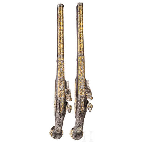 A pair of chiseled, gold and silver inlaid flintlock pistols crafted in France, circa 1810-1820.from