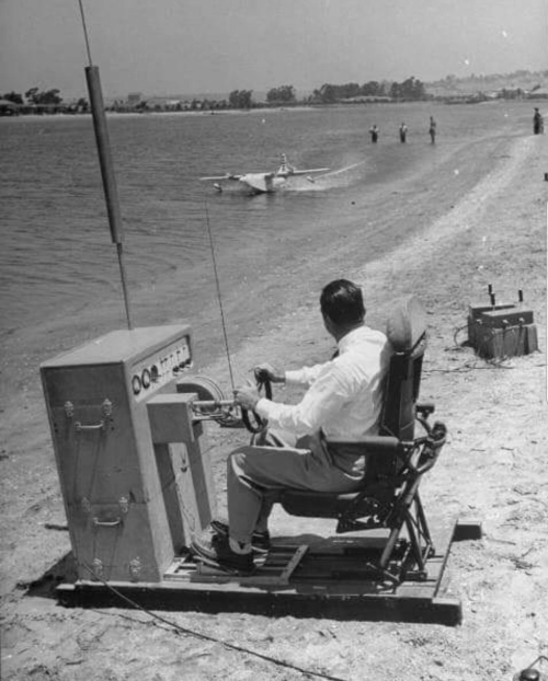 Howard Hughes operating a large remote control console for a RC model of his Spruce Goose flying boat. Circa mid 40s. Check this blog!