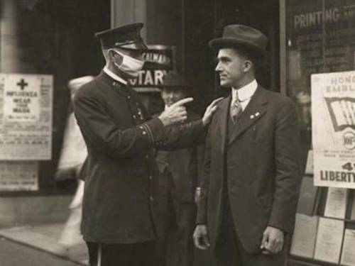 A policeman in San Francisco scolds a man for not wearing a mask during the 1918 Influenza Pandemic,