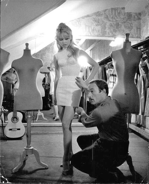 talesfromweirdland:Brigitte Bardot gets dressed by designer Jacques Esterel. Paris, 1958.