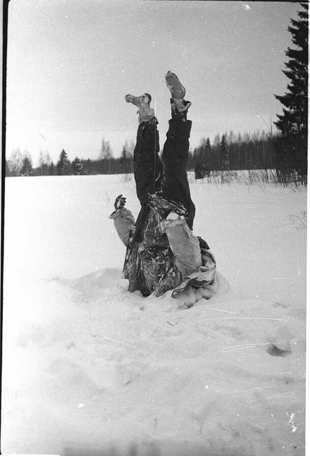 wwii-in-photographs:   The frozen body of a dead German soldier is used as a signpost.