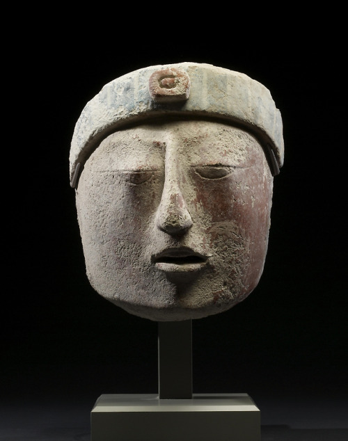 Ancient Maya stucco portrait head, bearing the headband of the maize deity.  Artist unknown; ca. 550