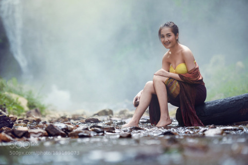 Sexy asian woman stone polishing in Waterfall