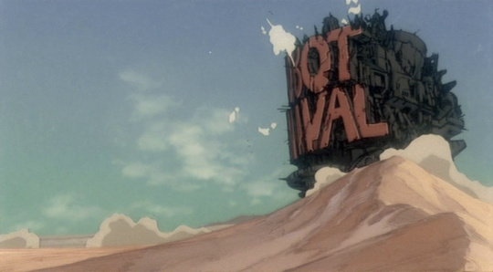 Still of the Robot Carnival, a gigantic tracked machine with the title in massive letters, on a sand dune.