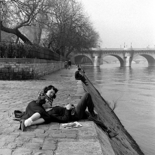 life:A couple relaxing on the banks of the Seine River in Paris, France - during the spring of 1949.