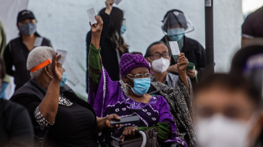 At a Kedren Community Health Center vaccine clinic in South Central Los Angeles this month, 89-year-old Cecilia Onwytalu (center) signals she