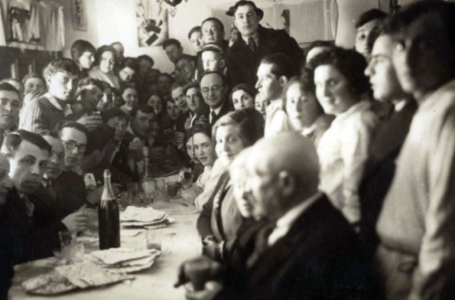 A Passover Seder in the Warsaw Ghetto, PolandJews around a Seder table reading from the Passover Hag