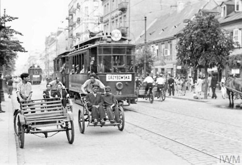 Transport in the Warsaw Ghetto in summer 1941:Street rickshaws and a tramcar carry passengers along 