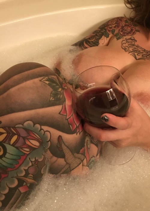 Tattooed leg and chest in tub with bare breast drinking wine.carriecapri.tumblr.comCarre Cap
