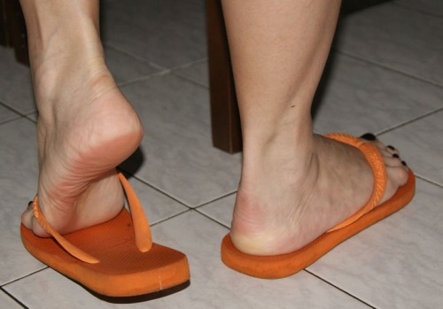 mesmerizingfeet: Slight footplay in orange Havaianas flip-flops.