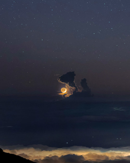 sitting-on-me-bum: Moonset: A crescent moon sets behind a cumulus cloud. Photographer Babak Tafreshi