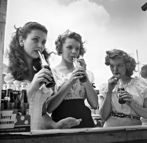 inthedarktrees:  Three young women drinking bottles of soda with straws, ca. 1956