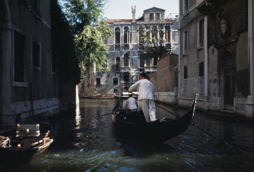 vintageeveryday:A pair of gondoliers navigate their craft through one of the small canals that criss