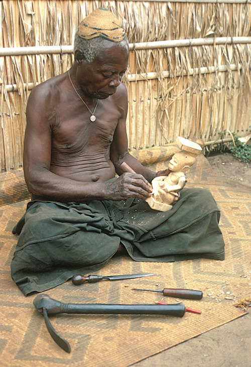 Via Vintage Congo:Kuba sculptor carving a dynastic statue called a ndop representing MboMboosh (Bom Bosh, Mbopey a-Mbwoosh a-Ipok), Mushenge