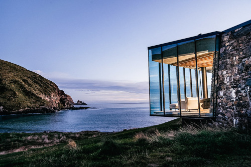 archatlas:    Seascape Retreat    Patterson AssociatesA romantic beachside cottage is set into a rock escarpment in a tiny boulder strewn South Pacific cove. It is a shelter designed as a honeymoon retreat for paying guests consisting of just three rooms,