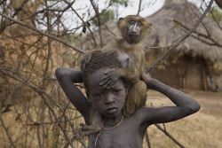 mvtionl3ss:    A boy and his pet baboon wander the Suri village of Tulgit. Tulgit, EthiopiaPhoto by Randy Olson.