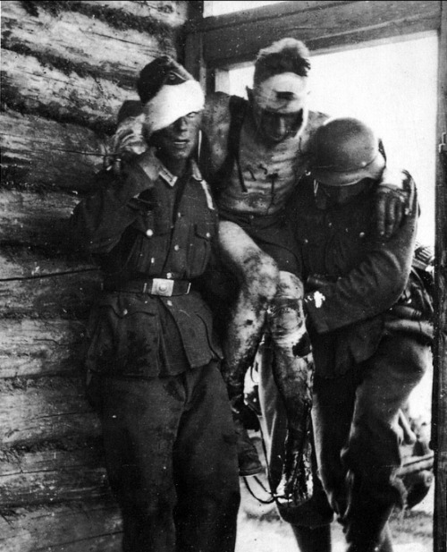  A severely wounded German soldier is transported by two comrades (one injured as well) to shelter on the Eastern Front, Russia, 1941/1942 
