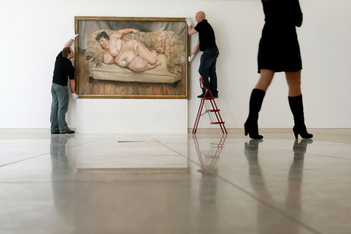 installator:  “Christies’ employees pose hanging Lucian Freud’s painting ‘Benefits Supervisor Sleepi