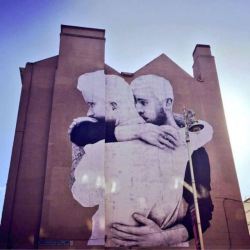 actegratuit:    An enormous four-story mural of two men embracing by Irish illustrator and street artist Joe Caslin went up overnight on South Great Georges Street in downtown Dublin, meant to be a “poignant representation of same-sex love in the city”