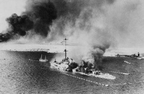 The Italian cruiser San Giorgio burning amidships in the harbour ofTobruk (February 18th, 1941).  Th