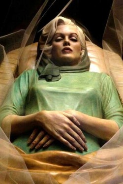 “At Rest”, by Italian artist Paolo Schmidlin, is a painted bronze  sculpture of Marilyn Monroe in her casket. The work presents the actress in the green dress and scarf she was buried in, complete with a veil covering her open coffin.