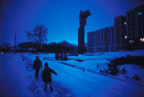 20aliens: MOLDOVA. Transdniester. 2004. Streetscene in front of a statue of Lenin, next to the Supreme Soviet building. / MOLDOVA. Transdniester. 2004. People headed to work in the morning. Jonas Bendiksen