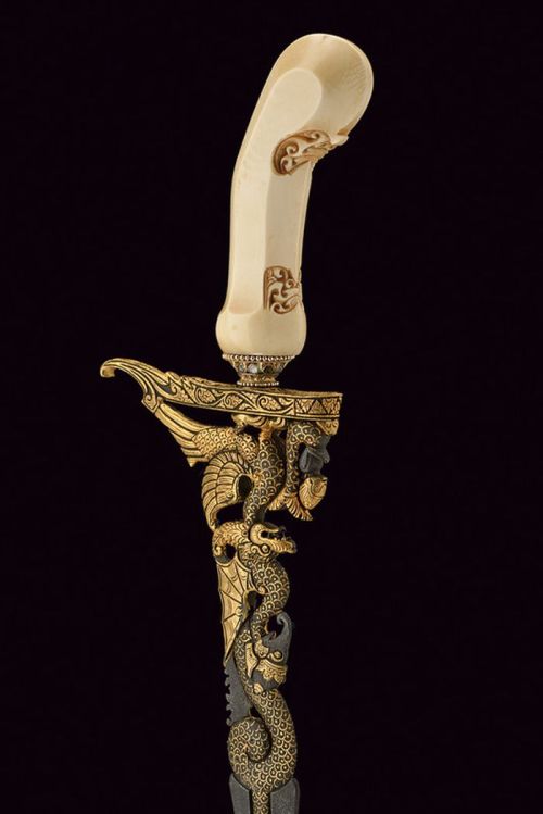 art-of-swords:  Kris Dagger Dated: 20th century Culture: Javanese Measurements: overall length 47.5 cm The dagger has an almost straight, double-edged blade with a curved tip, the first part being finely pierced, gold-plated and engraved with the effigy