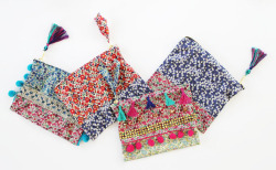 dreamalittlebiggerblog:  I adore these DIY embellished zippered pouches from The Liberty Craft Blog. The busy florals paired with ribbon, tassels, pom poms and more are busy but in a totally awesome way. Check out the full tutorial how how to sew these