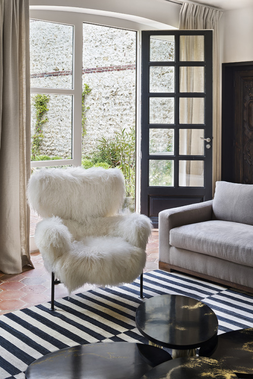 {Love that mix of the furry chair, the black and white rug, and the terracotta floor. Feels unexpect