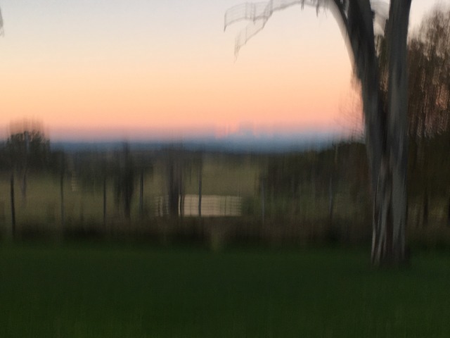a blurry photo of a sunset over farmland 
