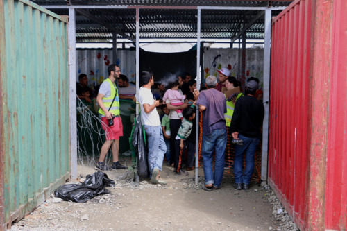 Volunteers providing people inside the camp with shoes and clothing. May 2016