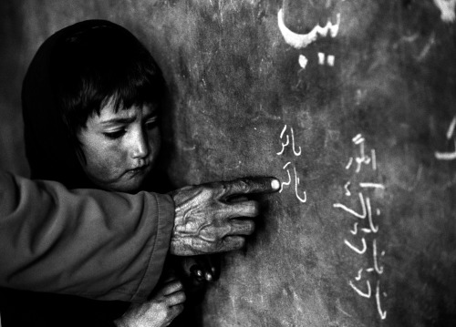 A girl stands at the blackboard in a classroom in the Central Asia Institute School, founded by Greg