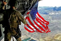 semperannoying:  U.S. Army Sgt. Michael Misheff flies the American flag from the back of a CH-47 Chinook helicopter over southern Kandahar province, Afghanistan, Aug. 24, 2014. Misheff is a crew chief assigned to 16th Combat Aviation Brigade. The pilots