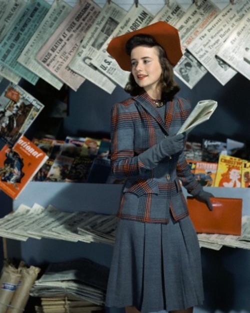 Dorothy Shapard, student at Vassar, reading in a career classic blue grey wool dress with a plaid ja