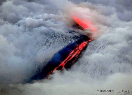 Fire, clouds, lava and ice&hellip;Mount Etna&rsquo;s basaltic lava streaming through the snowy peak 
