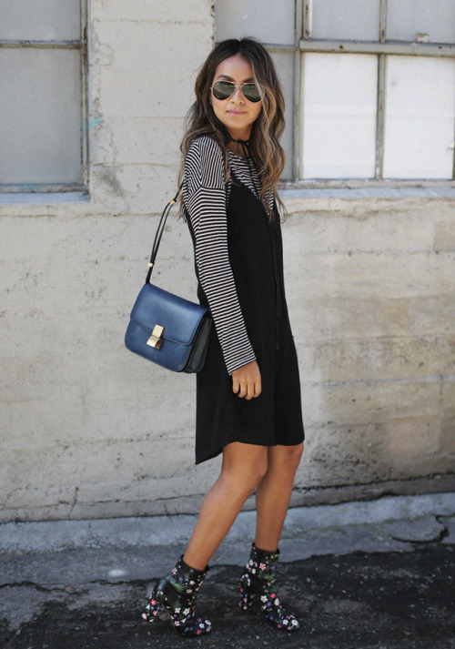 Julie Sarinana is wearing a black cotton slip dress over a simple black and white striped long sleev