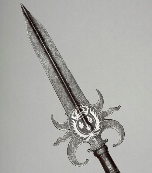 art-of-swords:  Partizans Photo #1 Attributed to Jean Berain I (1640 - 1711) Dated: circa 1670 - 1680 Culture: French Medium: steel, gold and velvet, etched, chiselled and gilded Measurements: blade length: 53.2 cm, straps length: 7.3 cm. Weight: 1.92 kg