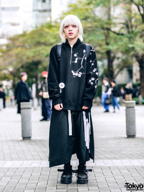 20-year-old Japanese fashion student Min on the street in Tokyo. He is wearing glitter makeup, a flo