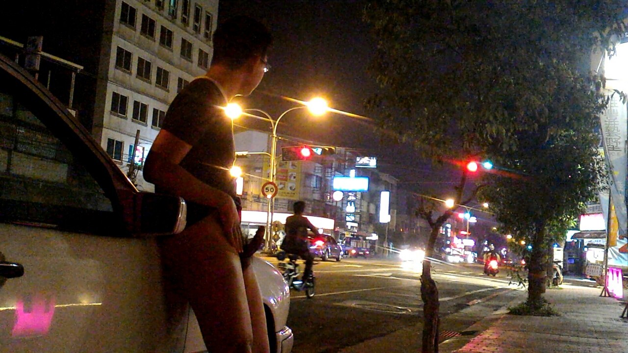 A naked Asian man shows off his hard cock, and masturbates, near a busy city intersection!