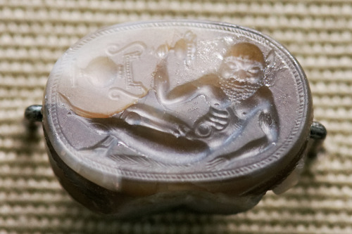 A reclining satyr holds a drinking cup.  Scarab from Etruria, eponymous gem of the Master of th